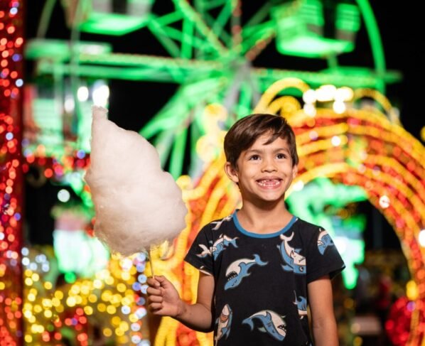 Garotinho em frente à roda-gigante do Natal do Bem