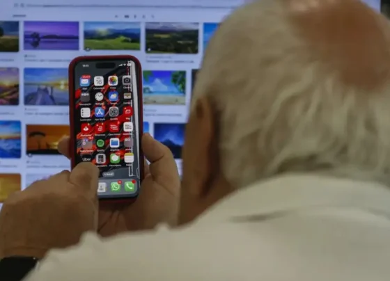 Imagem mostra idoso utilizando telefone celular