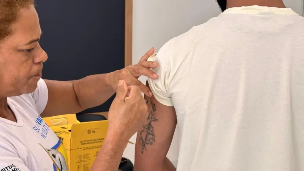 Imagem mostra trabalhador da linha de frente recebendo dose aplicada pela SMS